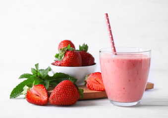 Glass of delicious strawberry homemade smoothie on light background