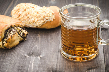pastries and glass with tea/pastries and glass with tea on a wooden table