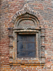 Window of old orthodox church with iron shutters in Krutitskoe podvorie, Moscow
