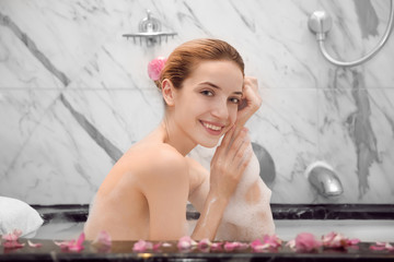 Woman relaxing in bath with foam. Spa treatment concept