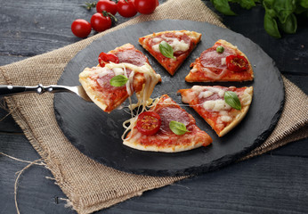 Hot true PEPPERONI ITALIAN PIZZA with salami and cheese. TOP VIEW Tasty traditional pepperoni pizza on board on wooden table with decoration