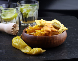 A plate of delicious tortilla nachos with melted cheese sauce, jalapeno peppers