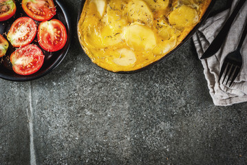 Mexican food. Traditional dish Tortilla de patatas - a casserole from potatoes and eggs, on a black stone table.