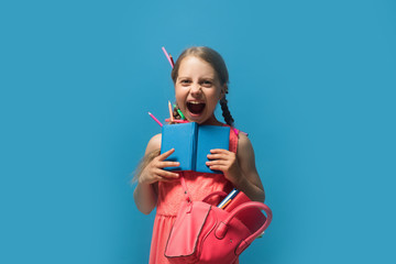 Girl with pink bag holds open blue notebook