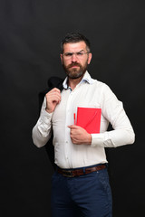 Man with glasses and beard holds red notebook