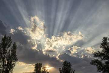 The sun's rays make their way through the clouds