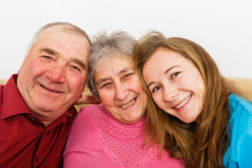 Happy elderly couple and young caregiver