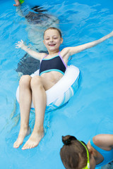 Happy little Girl in bikini swimming pool
