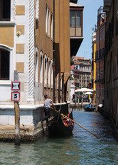 Fototapeta na wymiar Gondolier dans un canal de Venise, Italie