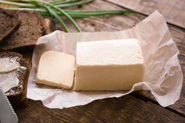 Piece of unwrapped butter on wooden table