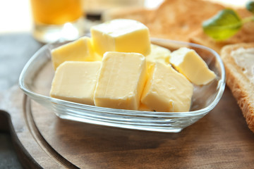 Glass bowl with cubes of butter on cutting board