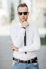 tylish handsome young man with bristle standing outdoors