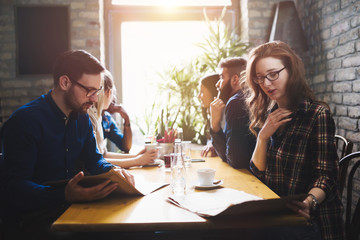 Colleagues from work socializing in restaurant and eating togeth