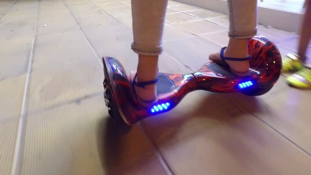 Girl riding on hoverboard at night, close up