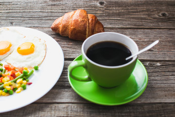 Coffee in a green mug on wooden surface