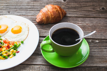 Coffee in a green mug on wooden surface