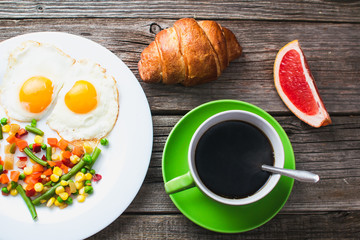 Coffee in a green mug on wooden surface