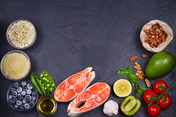 Detox healthy food concept with salmon fish, vegetables, fruits and ingredients for cooking. Selection of healthy and good for heart food. View from above, top studio shot
