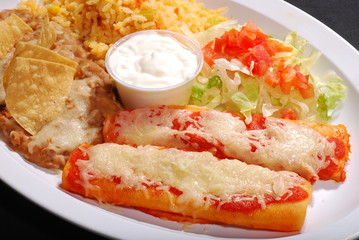 Red enchiladas with rice and beans, salad, cheese & sour  cream, chips