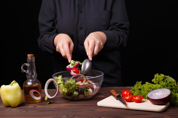 Mess, haste, cooking concept. Cook mixing salad scattering some food.