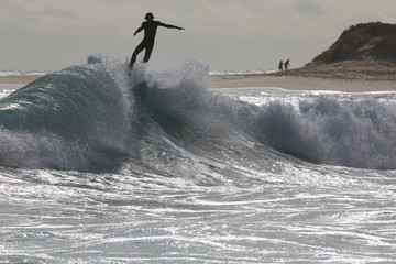 Surfer getting launched into the air from backwash at Margaret River in Western Australia