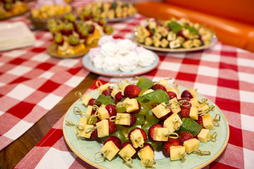 sweet buffet table. Beautifully decorated catering banquet table with burgers, profiteroles, salads and cold snacks. Variety of tasty delicious snacks on the table