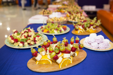 sweet buffet table. Beautifully decorated catering banquet table with burgers, profiteroles, salads and cold snacks. Variety of tasty delicious snacks on the table