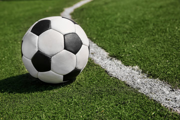 Fototapeta na wymiar Soccer ball on fresh green grass outdoors