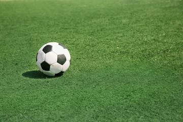 Soccer ball on fresh green grass outdoors