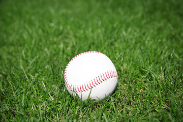 Baseball ball on fresh green grass outdoors