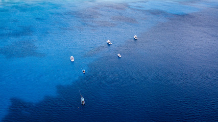 Aerial view of dive boats over a large underwater shipwreck