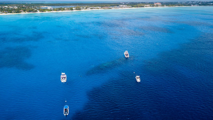 Boats over a large underwater shipwreck and tropical coral reef