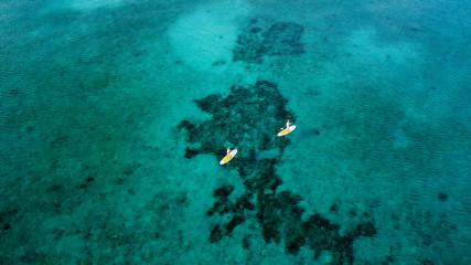 Fototapeta na wymiar Aerial view of stand up paddleboards over a tropical coral reef