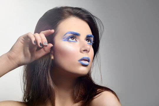 Beautiful young woman with creative make up on light background