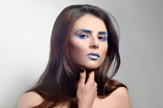 Beautiful young woman with creative make up on light background