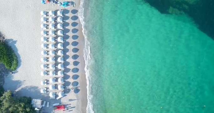 Video from above, aerial view of a turquoise sea and a white beach in Sardinia, Italy.