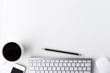 Modern white office desk top table with a cup of coffee, computer laptop, smartphone and other...