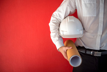 Engineer or Architect holding personal protective equipment safety helmet and architectural drawing...