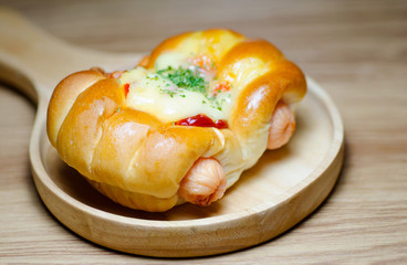 Bread with sausage on wooden plate