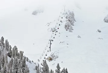 Fotobehang Ski lift chair ascending the mountainside © NatalieJean
