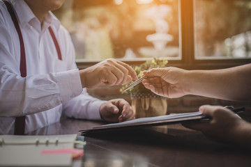 businessmen discussing and signing contract during business negotiations at coffee cafe
