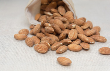 Burlap sack with almonds spilling out