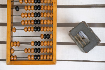 Old wooden abacus and a hole punch