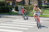 Young mum and little girl through the pedestrian strips with a b