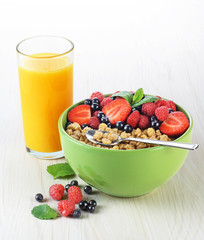 Muesli with fresh berries in a bowl on a light background.