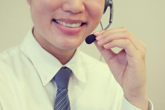 close up asian call center employee man smiling with service-mind,vintage tone color filter