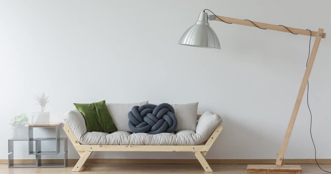 Wooden grey couch with pillows and oversize lamp