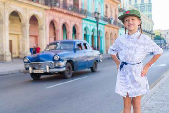 Adorable little girl in popular area in Old Havana, Cuba. Portrait of kid background vintage classic american car