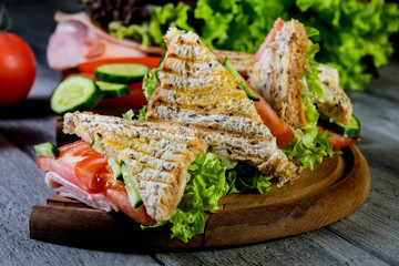 Panini sandwich with ham, tomato and lettuce.