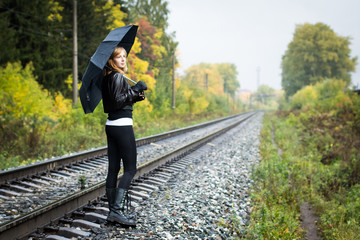 Girl, umbrella and rails in autumn
